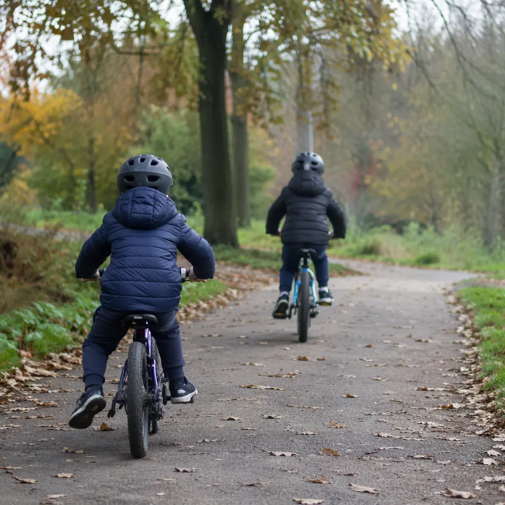 Children riding bikes on a quiet park path in the UK