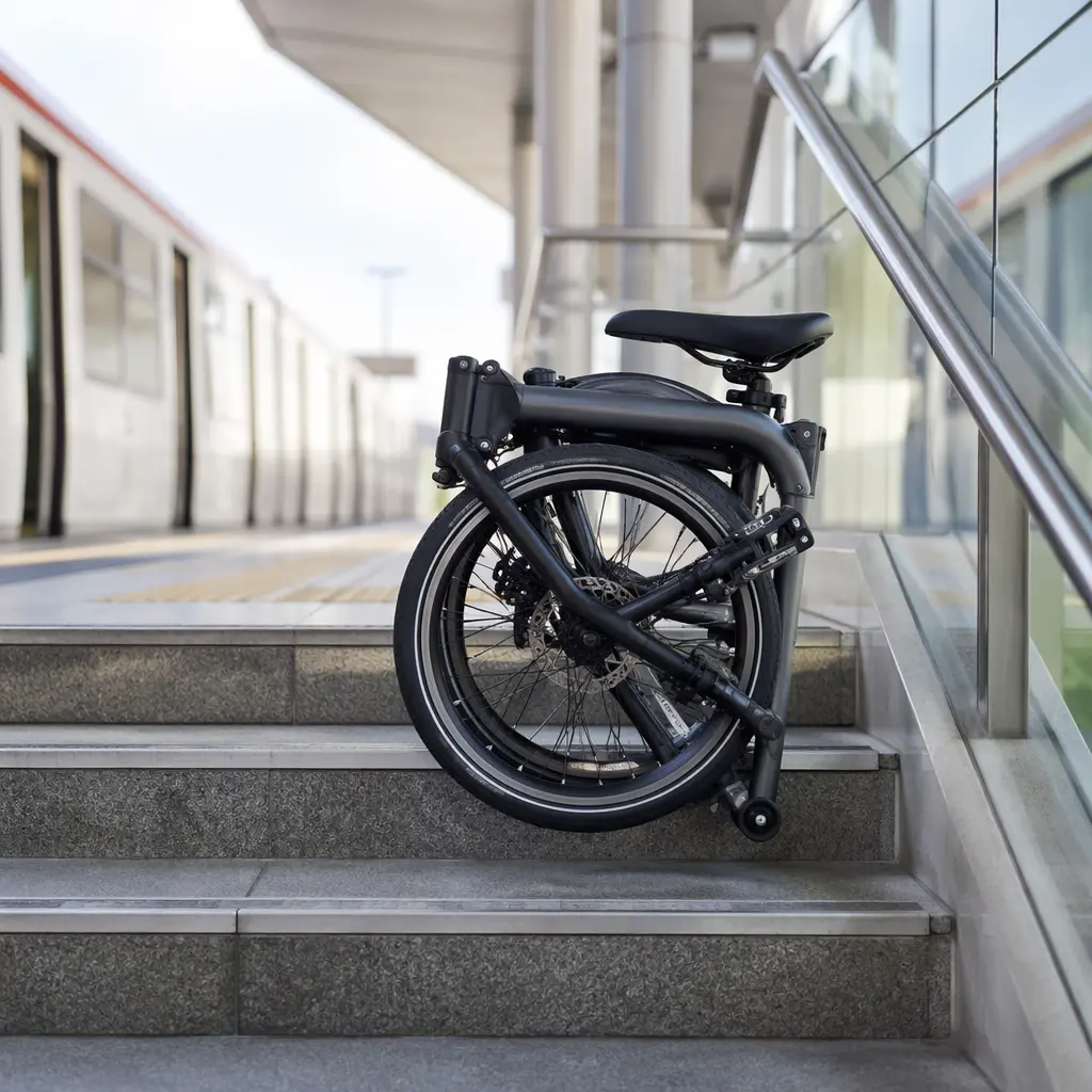 A folded bike positioned near station steps, highlighting its portable size.