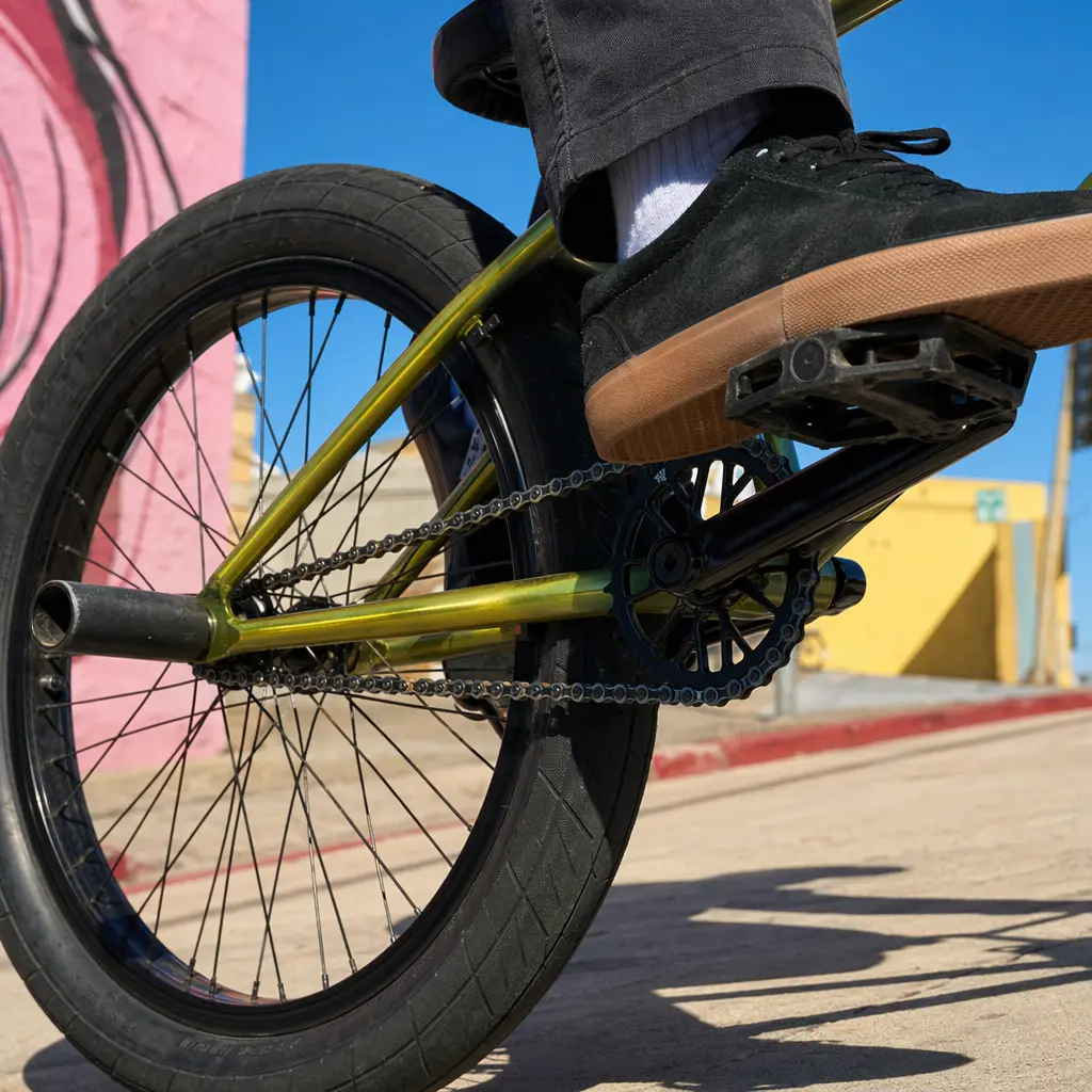 Close-up of a BMX bike’s rear wheel and single-speed drivetrain in bright sunlight