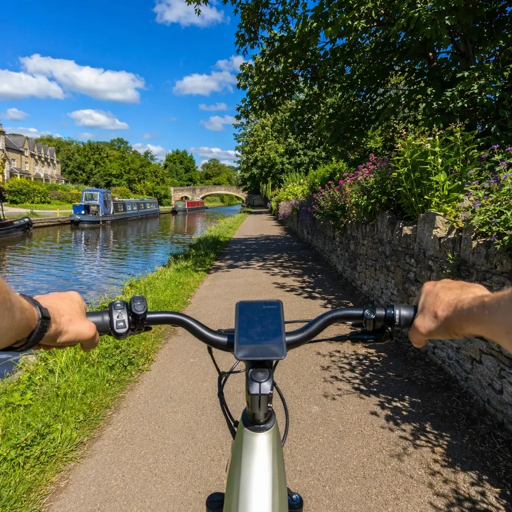 Electric bike riding along a sunny canal towpath under a bright blue sky