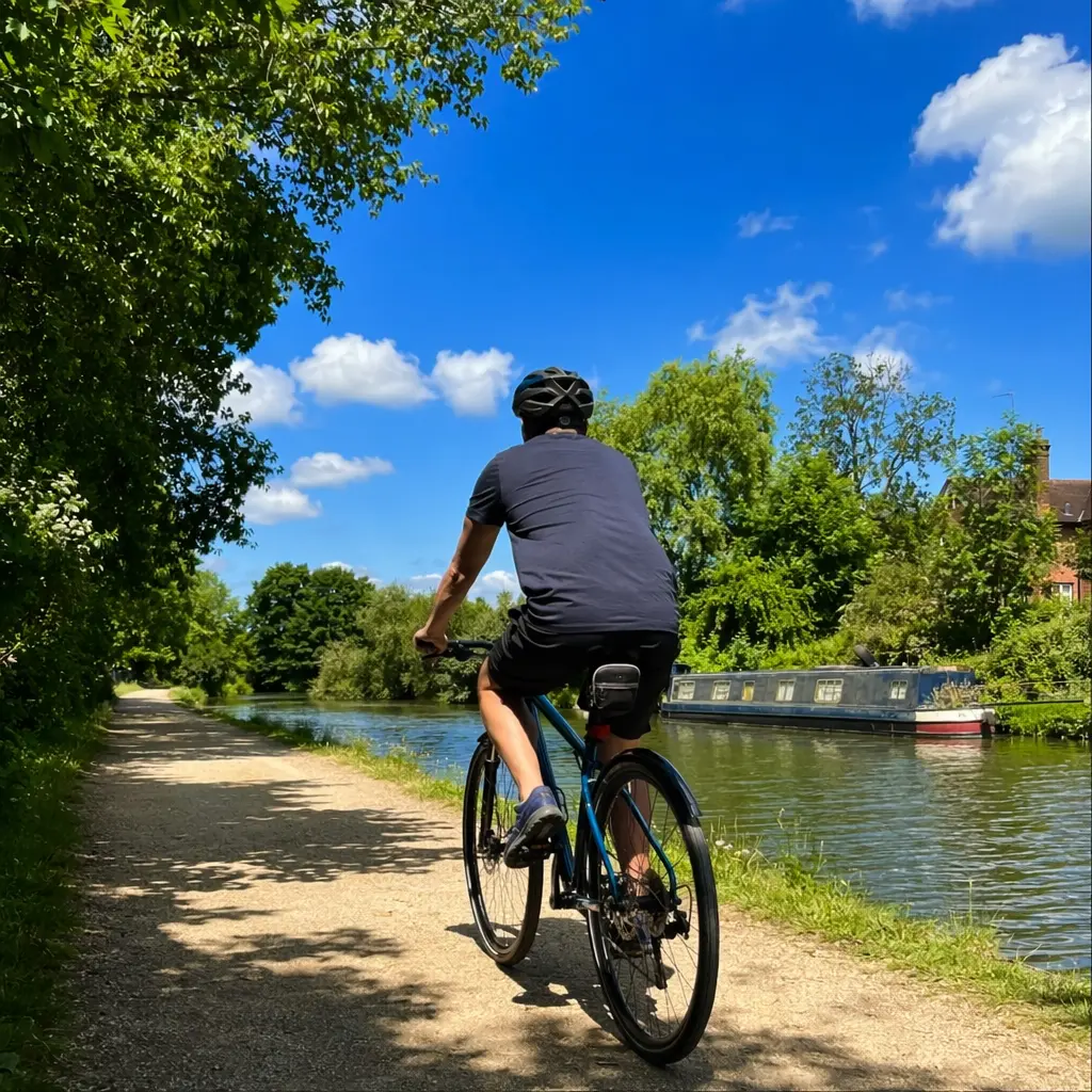 Suspension‑hybrid bike riding along a sunny UK canal towpath