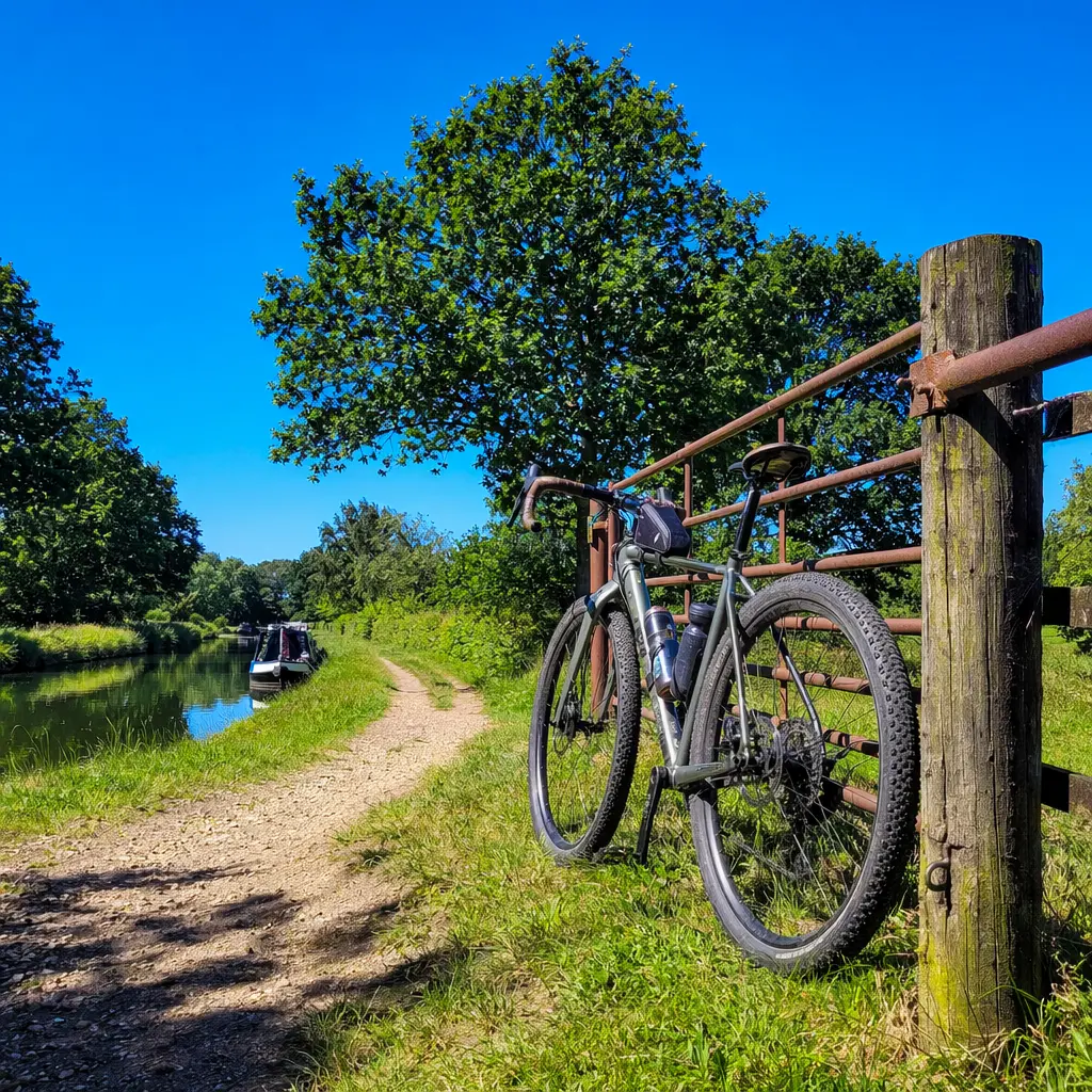 Gravel bike beside a UK canal towpath under a bright summer sky